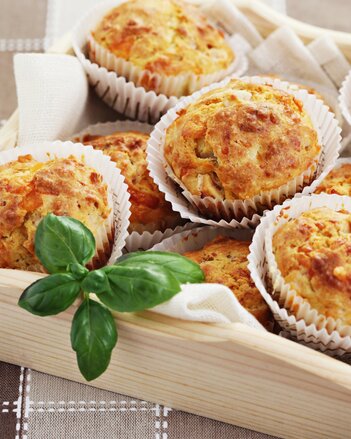 Auf dem Foto sind mehrere Gute Laune Kräutermuffins zu sehen. Auch Basilikum Blätter sind zu sehen. | © SONNENTOR