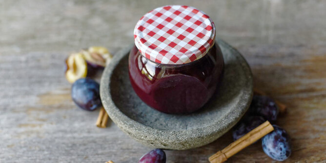 Zwetschken Marmelade | © SONNENTOR Auf dem Foto ist ein Glas Zwetschken Marmelade zu sehen. Daneben sieht man frische Zwetschken und Zimtstangen. | © SONNENTOR