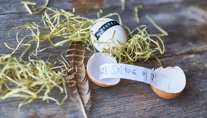 Nudelholz Ostern Glücksei | © SONNENTOR Auf dem Fot sieht man ein aufgebrochenes Ei mit einem Zettel darin. Auf dem Zettel steht: Hab Sonne im Herz. | © SONNENTOR