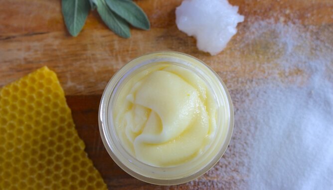 Deo Creme | © SONNENTOR Auf dem Foto ist ein Gläschen mit Deo Creme zu sehen. Daneben sieht man eine Honigwabe. | © SONNENTOR