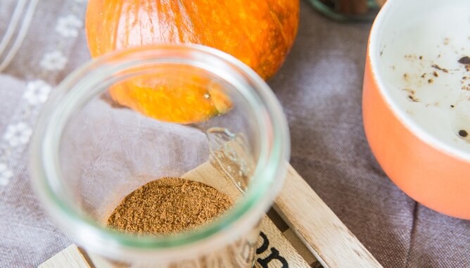 Pumpkin Spice Gewürzmischung | © SONNENTOR Auf dem Foto ist in einem Glas die Pumpkin Spice Gewürzmischung zu sehen. Im Hintergrund sieht man einen Kürbis. | © SONNENTOR