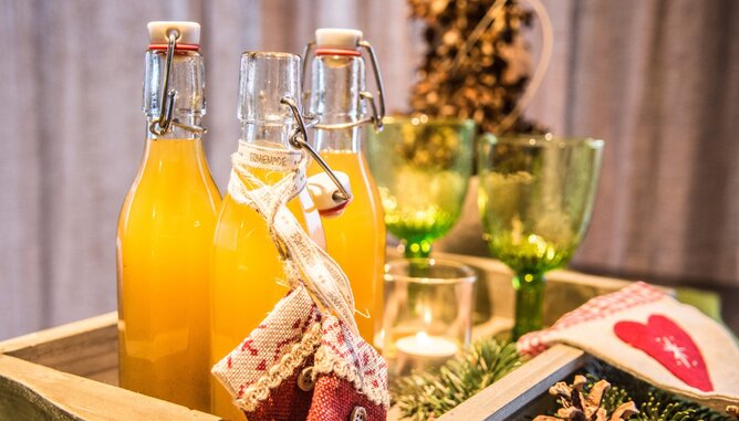 Punsch in Flaschen | © SONNENTOR Auf dem Foto sieht man drei Flaschen mit Punsch. Um eine der Flaschen wurden Weihnachtssäckchen gehängt. | © SONNENTOR