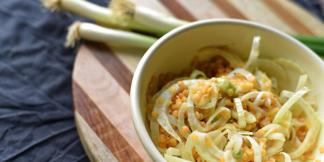 Rauchiger Linsensalat mit Fenchel | © SONNENTOR Auf dem Foto ist eine Schüssel mit Linsensalat mit Fenchel zu sehen. Im Hintergrund sieht man Lauch. | © SONNENTOR
