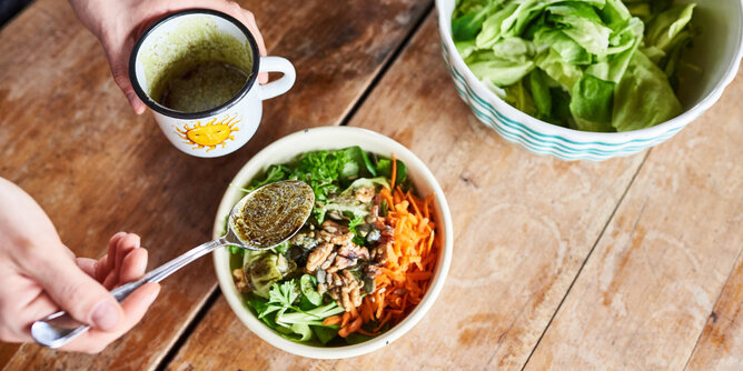 Superfood | © SONNENTOR Auf dem Foto sieht man eine Schale mit buntem Salat und Superfoods darin. Man sieht wie jemand ein Dressing darüber gießt. | © SONNENTOR