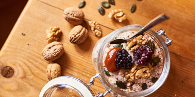 Nudelholz Superfood | © SONNENTOR Auf dem Foto sieht man ein Glas mit Porridge. Getopped ist er mit zahlreichen Superfoods wie Kürbiskerne, Walnüsse und Brombeeren. | © SONNENTOR