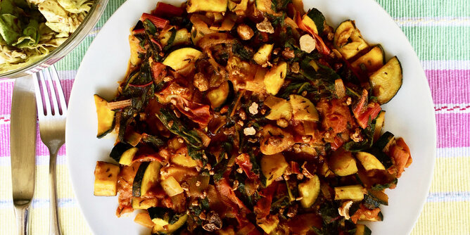 Mangold Kokos Curry | © SONNENTOR Auf dem Foto ist ein Teller mit Mangold Kokos Curry zu sehen. Neben dem Teller liegen Messer und Gabel. | © SONNENTOR