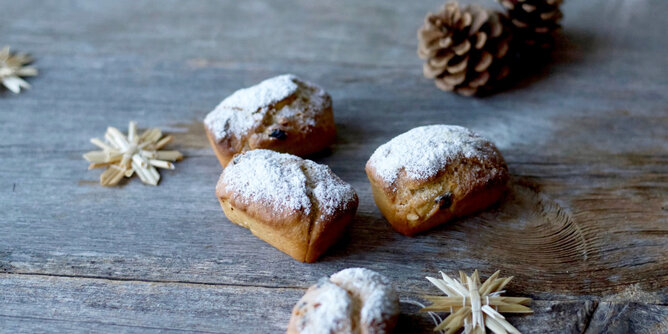 Mini-Gewürzstollen | © SONNENTOR Auf dem Foto sind Mini-Gewürzstollen zu sehen. Daneben liegen auch kleine Holzsterne und Zapfen. | © SONNENTOR