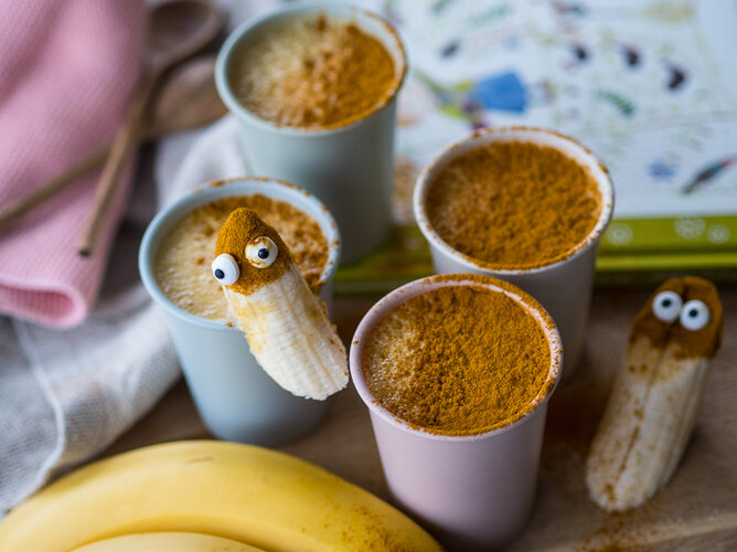 Familienfrühstück | © SONNENTOR Auf dem Foto sind vier Tassen Früchte-Tee-Kompott zu sehen. Auf die Tassen sind Bananen mit Augen gesteckt. | © SONNENTOR
