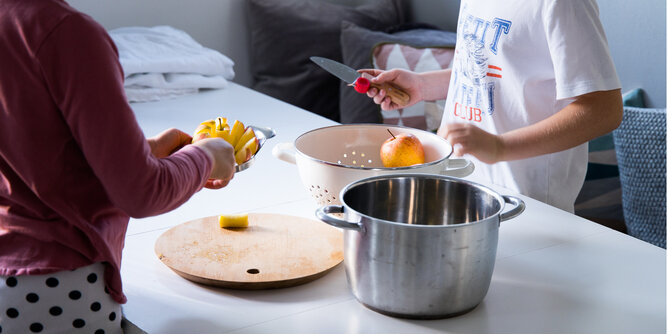 Äpfel schneiden | © SONNENTOR Auf dem Foto sind zwei Kinder zu sehen die Äpfel schneiden. | © SONNENTOR