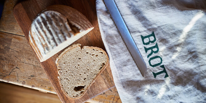 Brot | © SONNENTOR Auf dem Foto ist ein halber Laib Brot zu sehen. Davon wurde eine Scheibe abgeschnitten. | © SONNENTOR