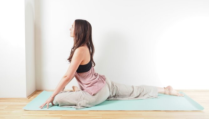 Auf dem Foto sieht man eine junge Frau in der Yogaposition Die Taube. | © SONNENTOR Die Yoga Taube | © SONNENTOR