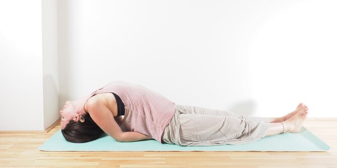 Auf dem Foto ist eine junge Frau in der Yogaposition Fisch zu sehen. | © SONNENTOR Yogastellung Fisch | © SONNENTOR