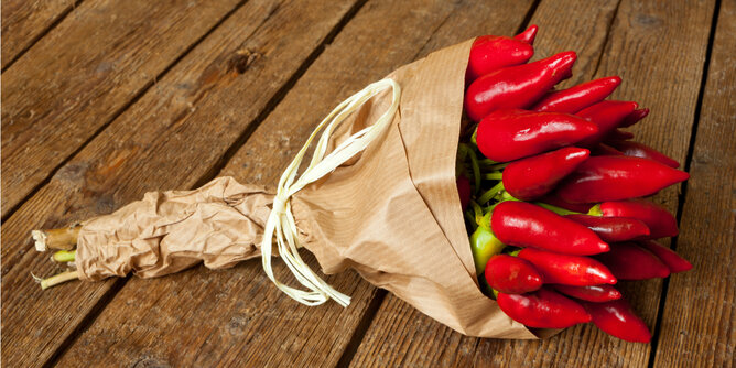 Natürliche Scharfmacher Chili | © SONNENTOR Auf dem Foto ist ein Strauß mit Chilis zu sehen. Er ist wie ein Blumenstrauß mit Papier umhüllt. | © SONNENTOR