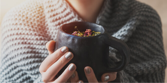 Basenfasten | © SONNENTOR Auf dem Foto sieht man wie jemand eine Tasse mit verschiedenen Kräutern in den Händen hält. | © SONNENTOR