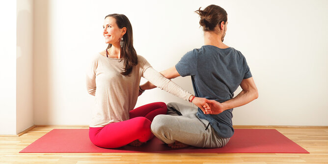 Partneryoga Flow | © SONNENTOR Auf dem Foto sind zwei Personen bei einer Yoga Partnerübung zu sehen. | © SONNENTOR